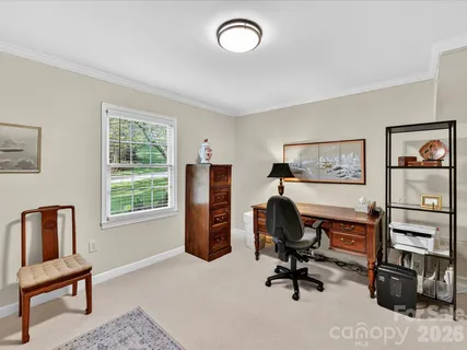 a view of a workspace with furniture and a window