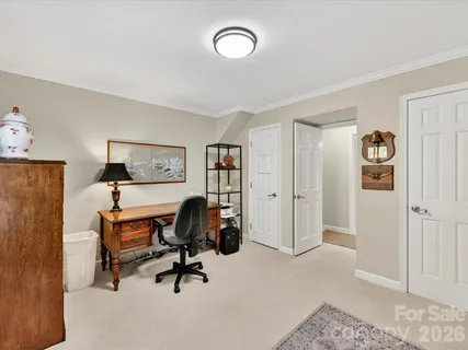 a view of a workspace with furniture and a window