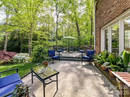 a view of a patio with table and chairs potted plants and a large tree