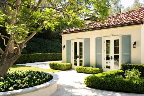 a view of a house with a yard and potted plants