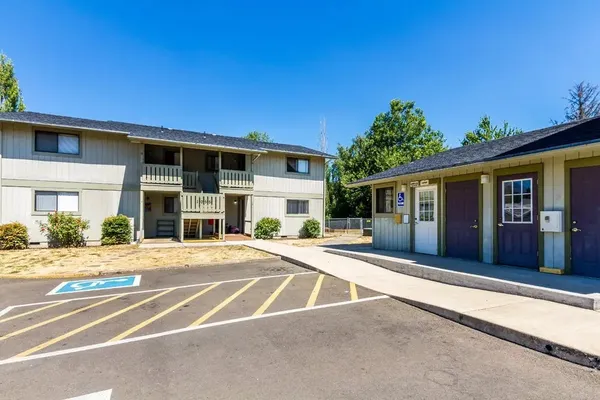 a front view of a house with a garden and parking