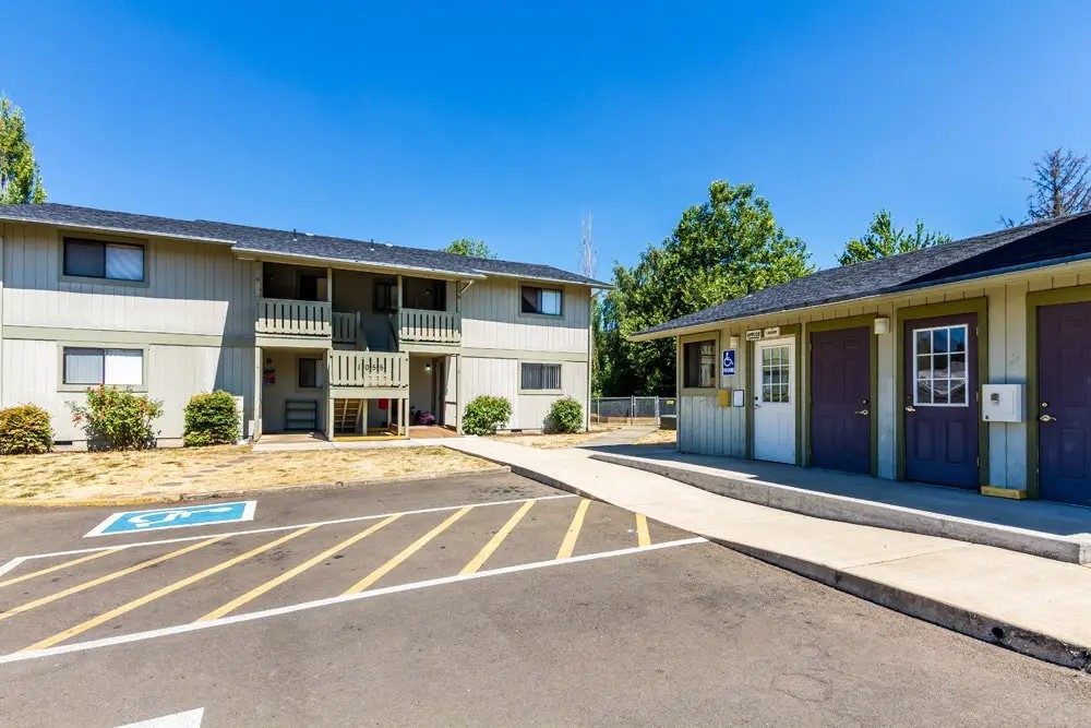 1051 East Central Avenue Sutherlin, OR 97479 - Photo 4 of 9 a front view of a house with a garden and parking