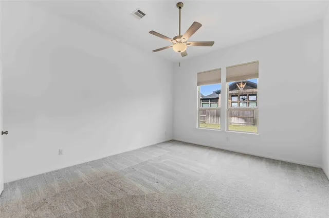 an empty room with a window and a fan