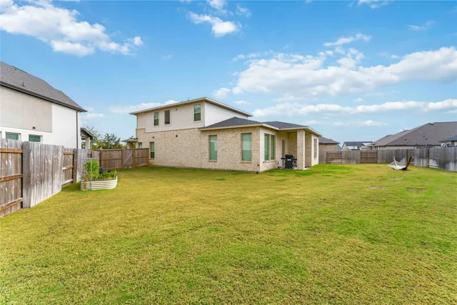a view of a house with a backyard and a tree