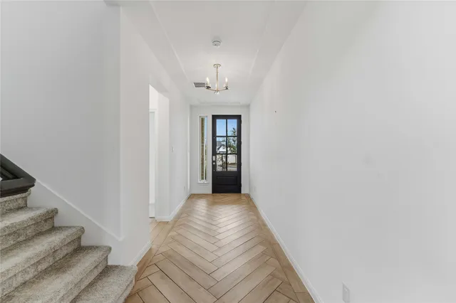 a view of a hallway with wooden floor and staircase
