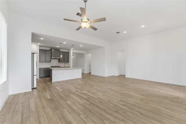 a view of large kitchen with granite countertop a sink and dishwasher with wooden floor