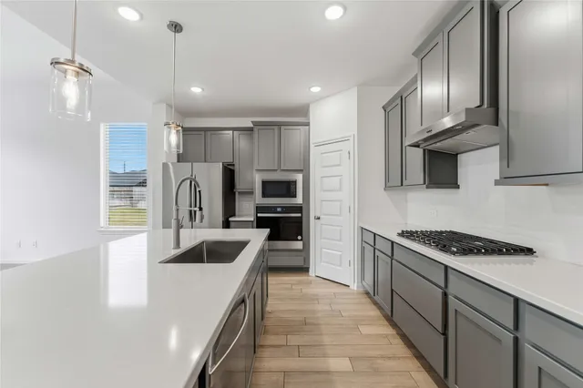 a kitchen with kitchen island stainless steel appliances a sink stove and refrigerator