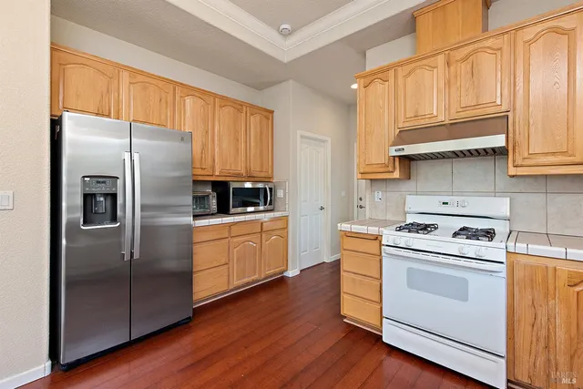a kitchen with stainless steel appliances granite countertop a stove a refrigerator and a refrigerator