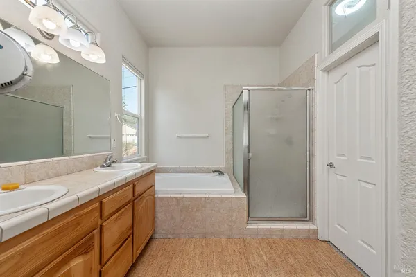 a bathroom with a granite countertop sink a mirror and a bathtub