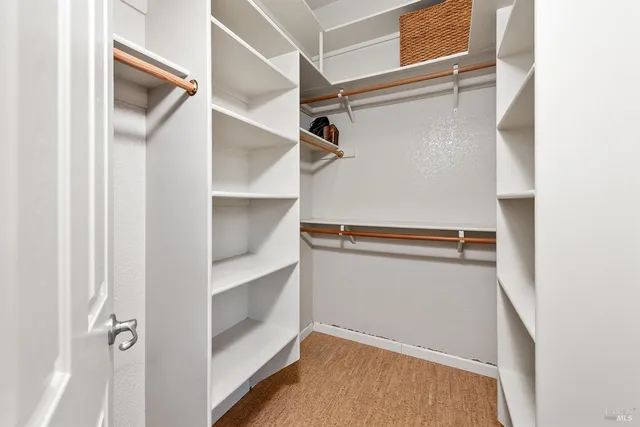 a view of walk in closet with empty racks