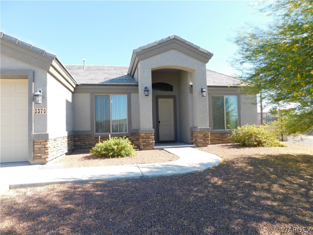 3370 South Ridge Avenue Bullhead City, AZ 86429 - Photo 4 of 56 a front view of a house with a yard