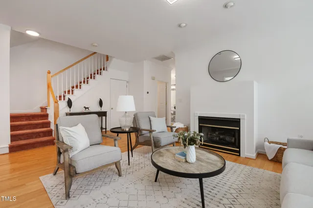a living room with furniture a fireplace a rug and a window