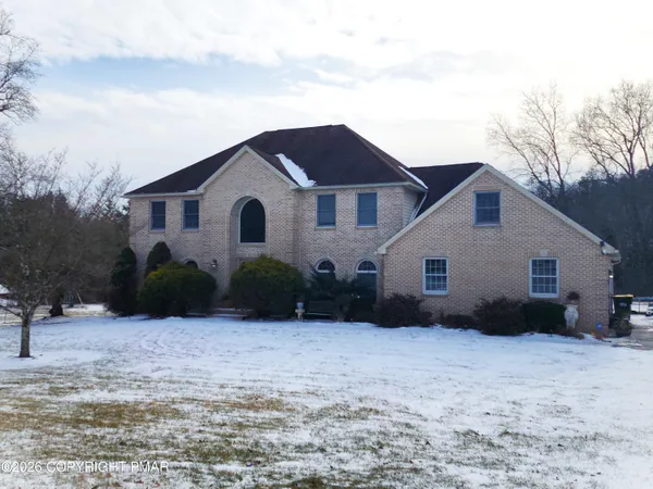 a view of a house with a yard covered with snow in the background