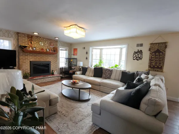 a living room with furniture fireplace and a window