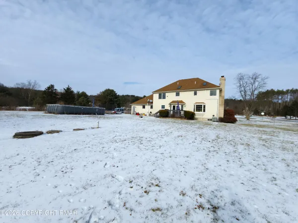 a view of a house with a yard covered in snow