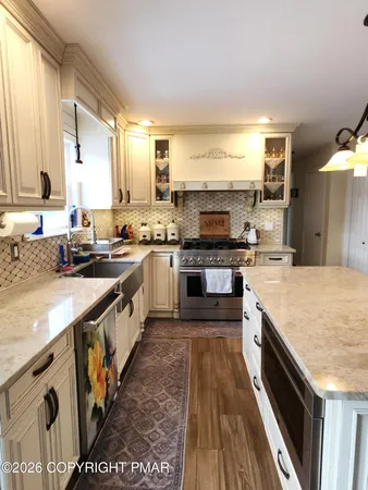 a kitchen with stainless steel appliances granite countertop a refrigerator and a stove top oven