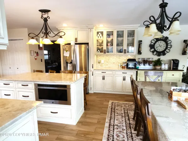 a kitchen with a dining table chairs sink and stove