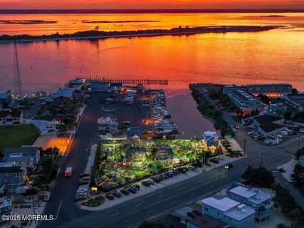 an aerial view of ocean and residential houses with outdoor space