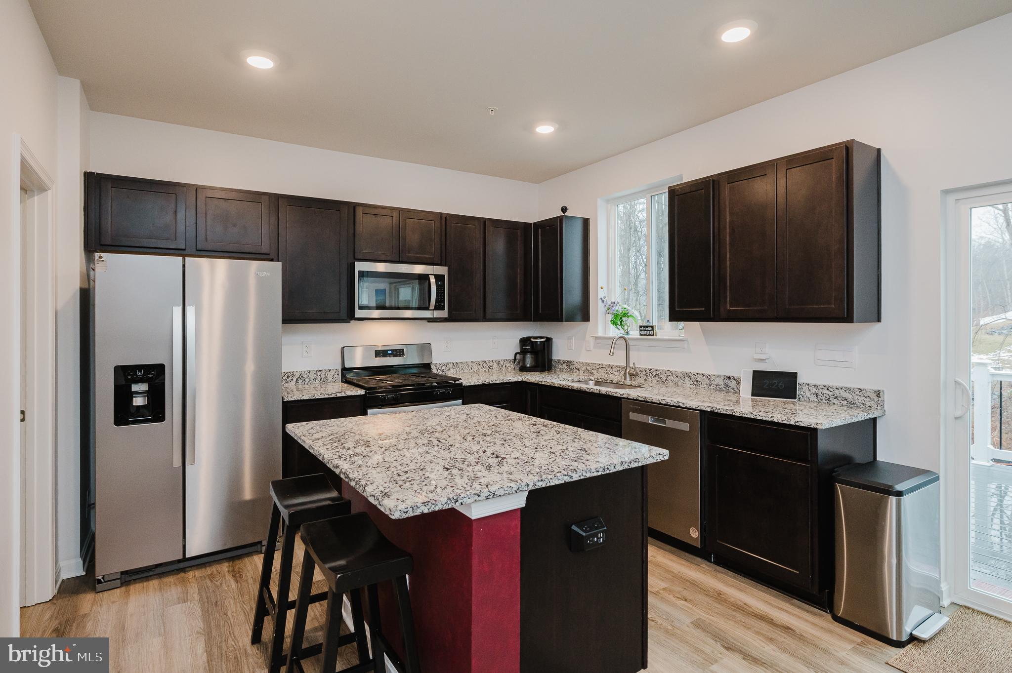976 Pagonia Road Joppa, MD 21085 - Photo 12 of 69 a kitchen with a sink a microwave a refrigerator and chairs