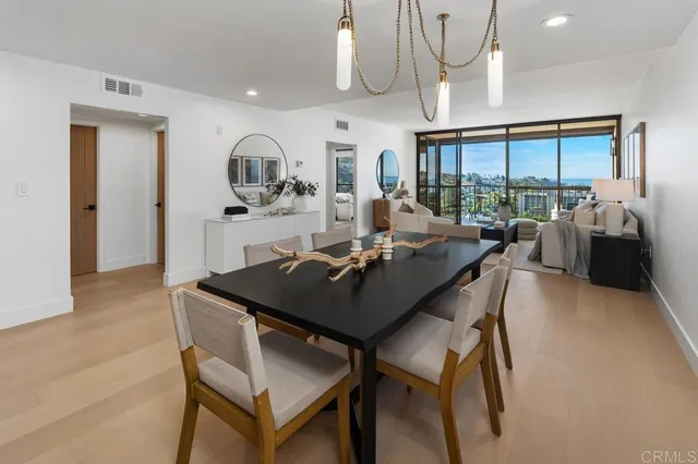 a kitchen with stainless steel appliances granite countertop a table chairs stove and refrigerator