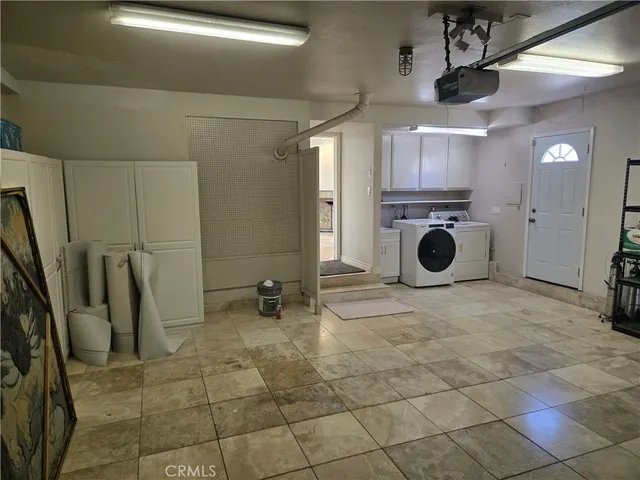 a kitchen with kitchen island granite countertop a refrigerator and a sink