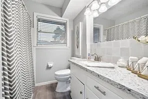 a bathroom with a granite countertop sink mirror vanity and a toilet