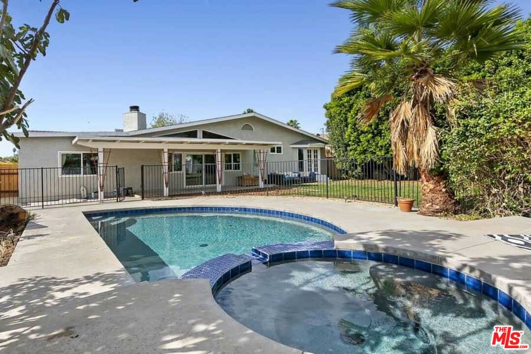 8460 Hatillo Avenue Winnetka, CA 91306 - Photo 18 of 19 a view of a house with a swimming pool