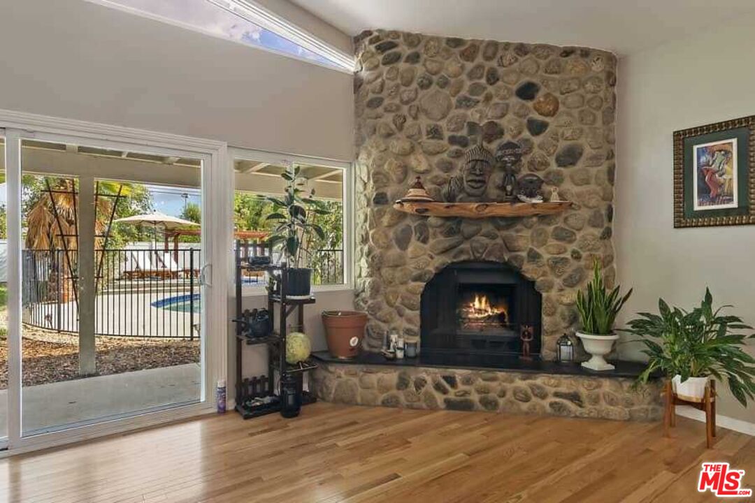 8460 Hatillo Avenue Winnetka, CA 91306 - Photo 8 of 19 a living room with a fireplace and potted plants