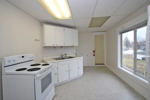 a kitchen with cabinets appliances a sink and a large window