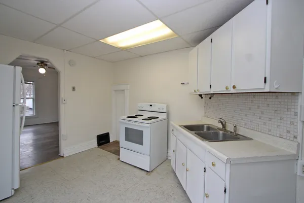 a kitchen with white cabinets and white appliances