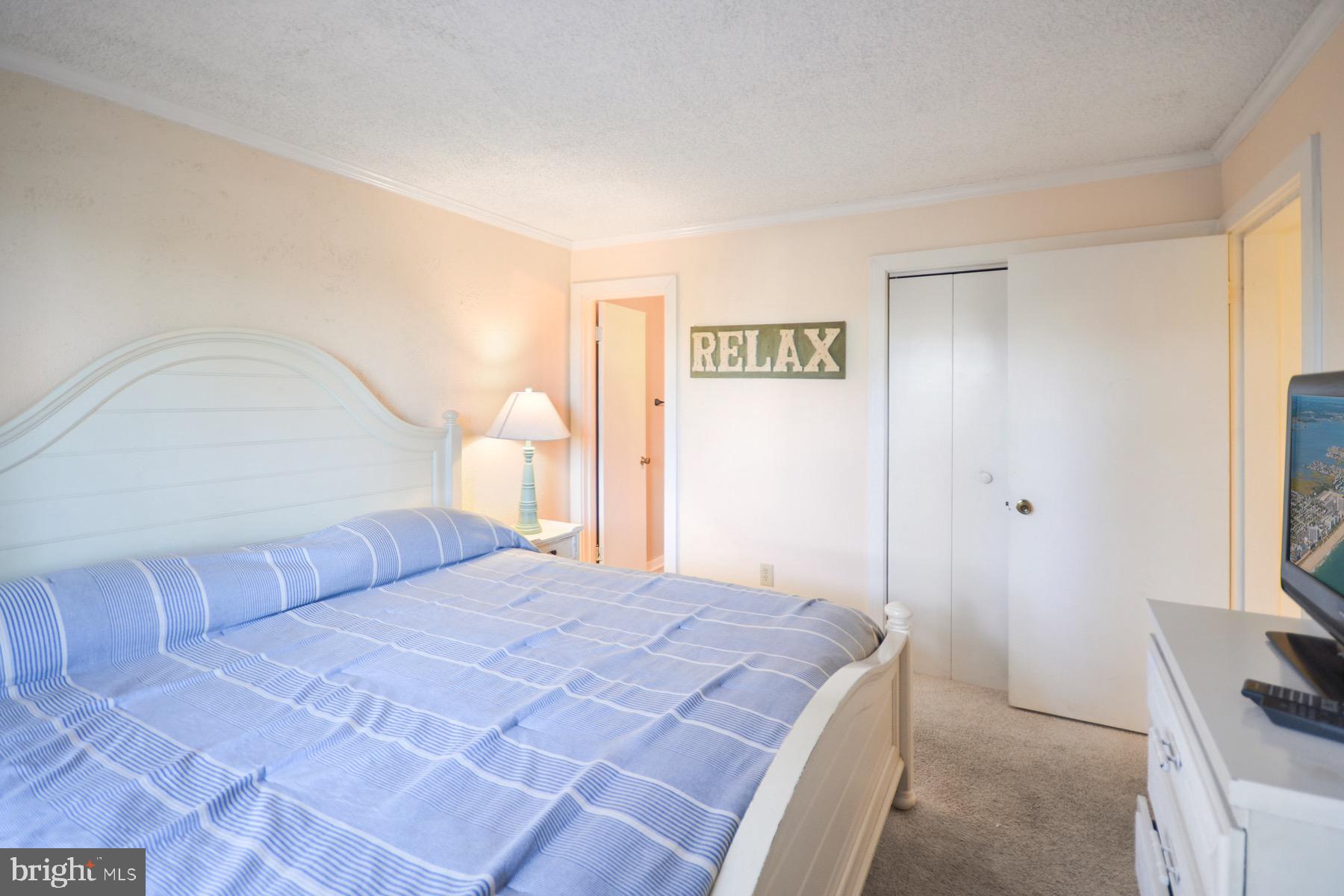 119 Old Landing Road, Unit 204J Ocean City, MD 21842 - Photo 13 of 35 a bedroom with a bed and a flat screen tv
