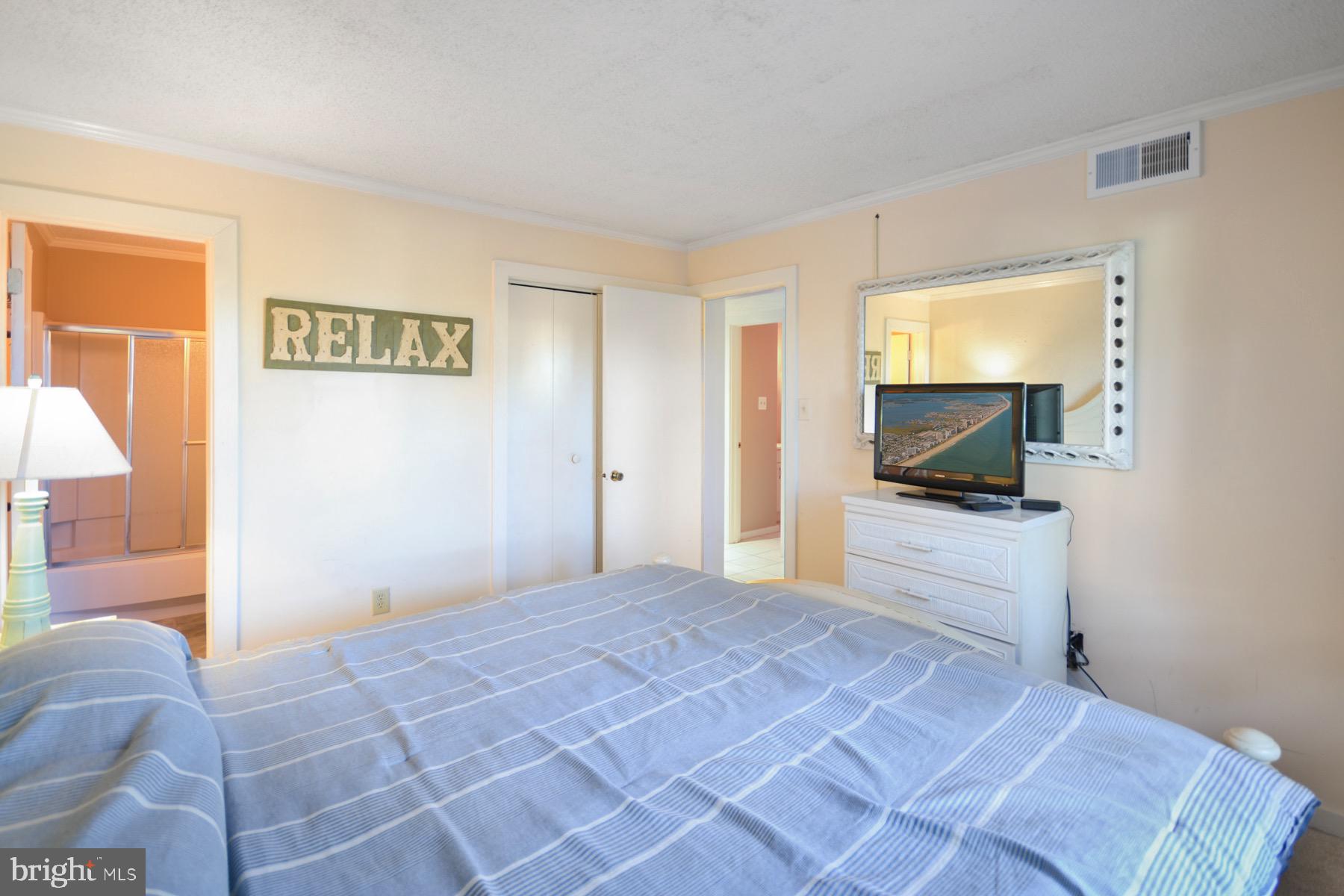 119 Old Landing Road, Unit 204J Ocean City, MD 21842 - Photo 14 of 35 a view of a bedroom with a bed and a flat screen tv