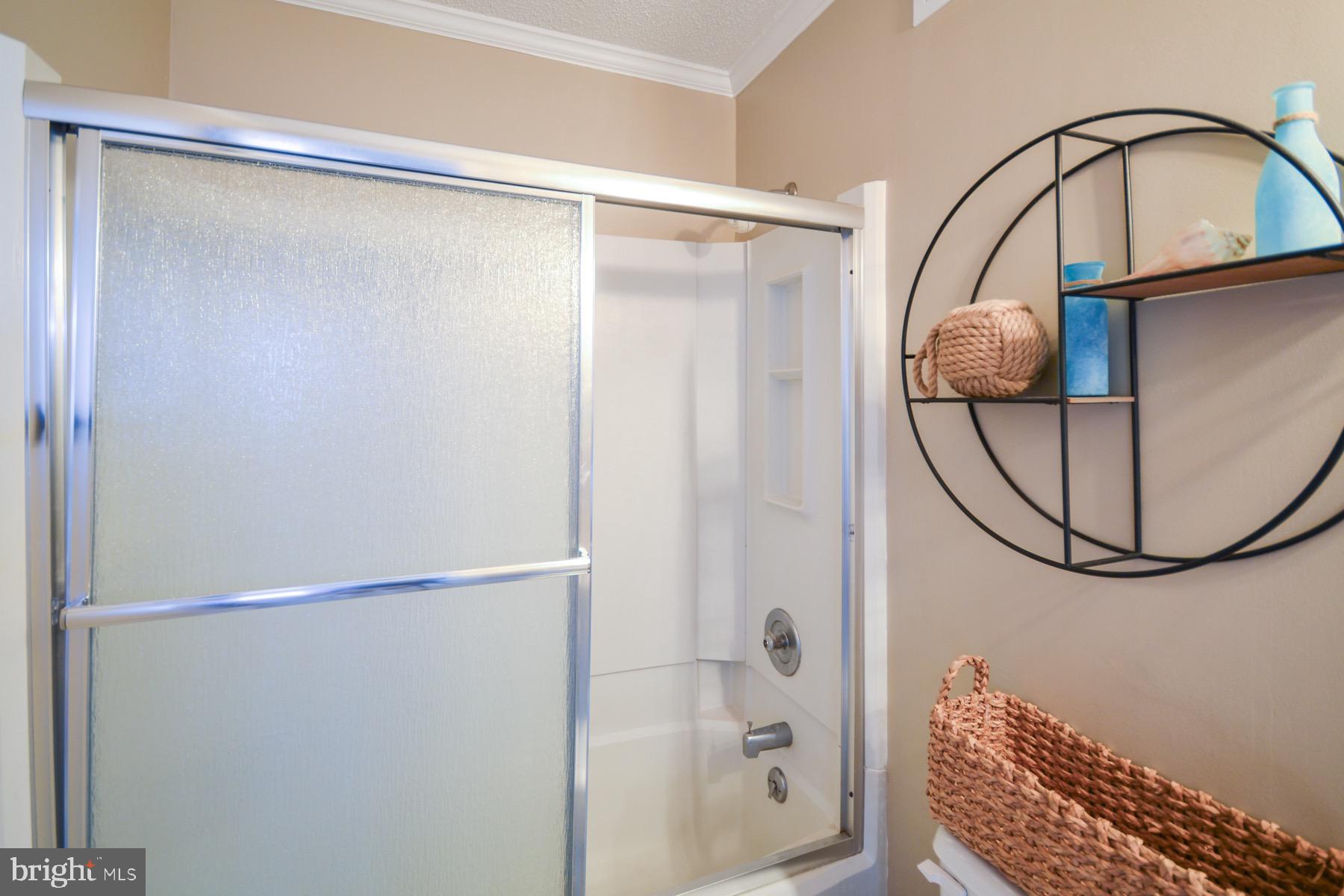 119 Old Landing Road, Unit 204J Ocean City, MD 21842 - Photo 16 of 35 a bathroom with a glass shower door and a mirror
