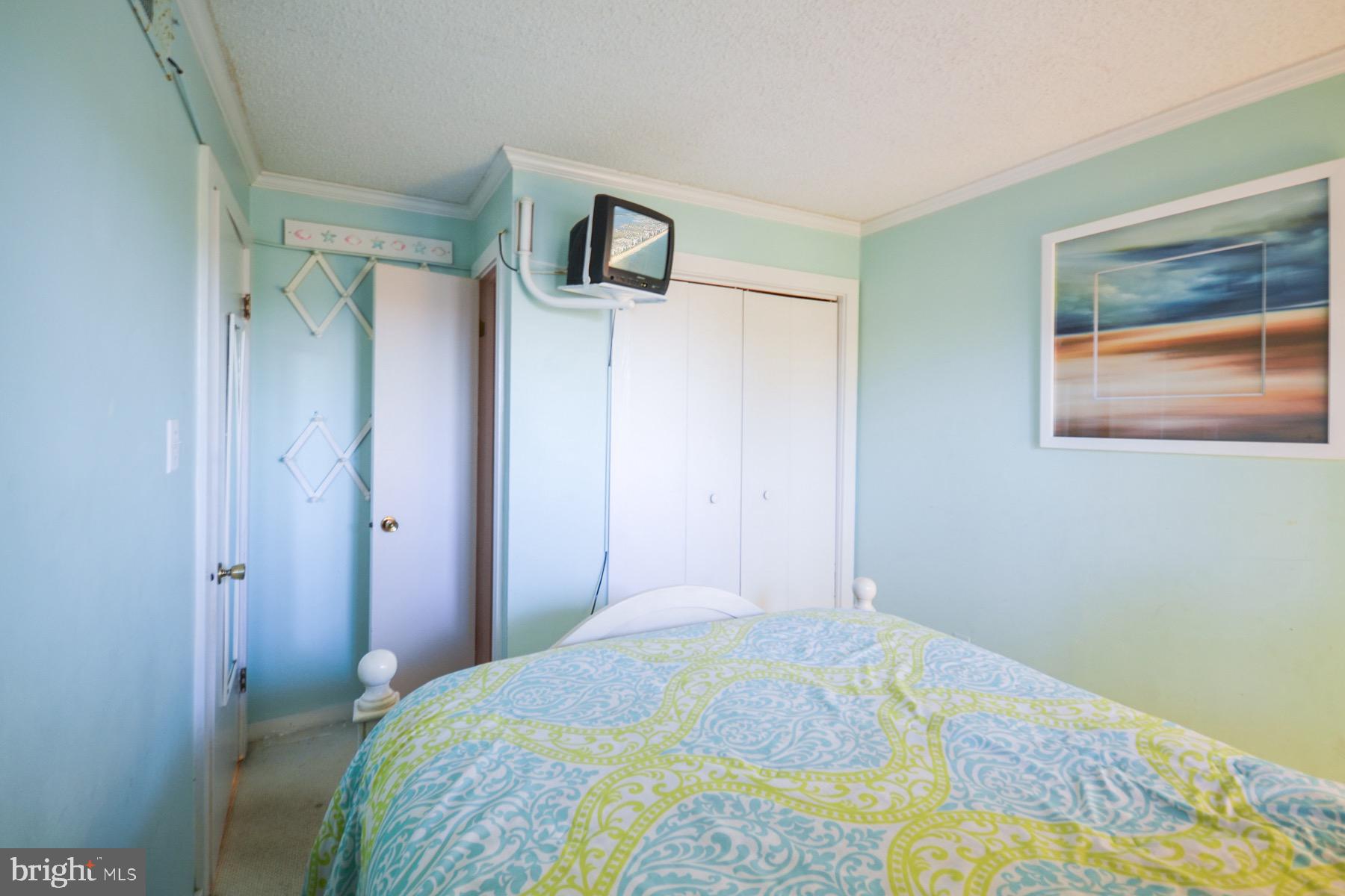 119 Old Landing Road, Unit 204J Ocean City, MD 21842 - Photo 20 of 35 a bedroom with a bed and a painting on the wall