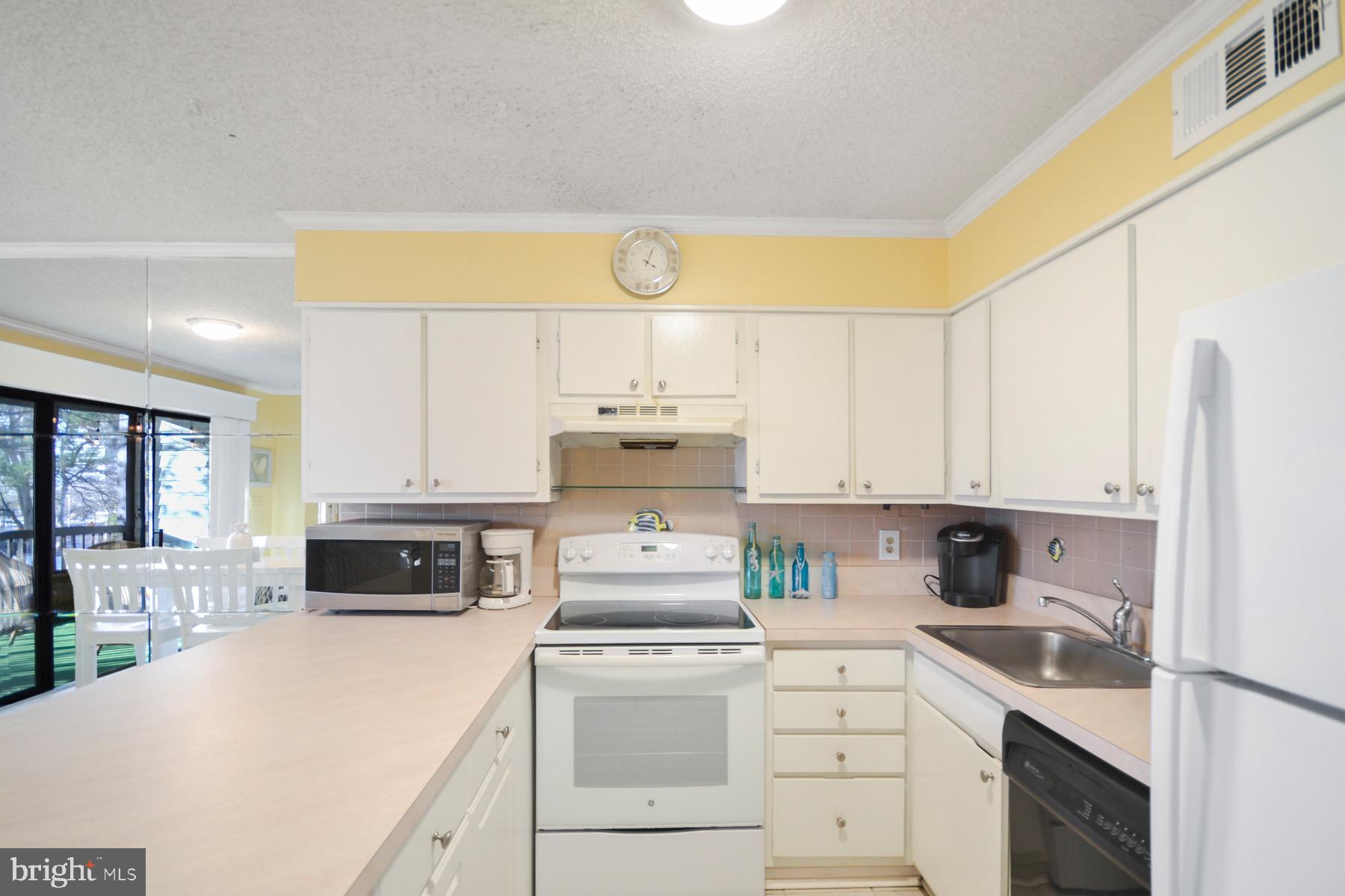 119 Old Landing Road, Unit 204J Ocean City, MD 21842 - Photo 3 of 35 a kitchen with kitchen island a stove a sink and a microwave