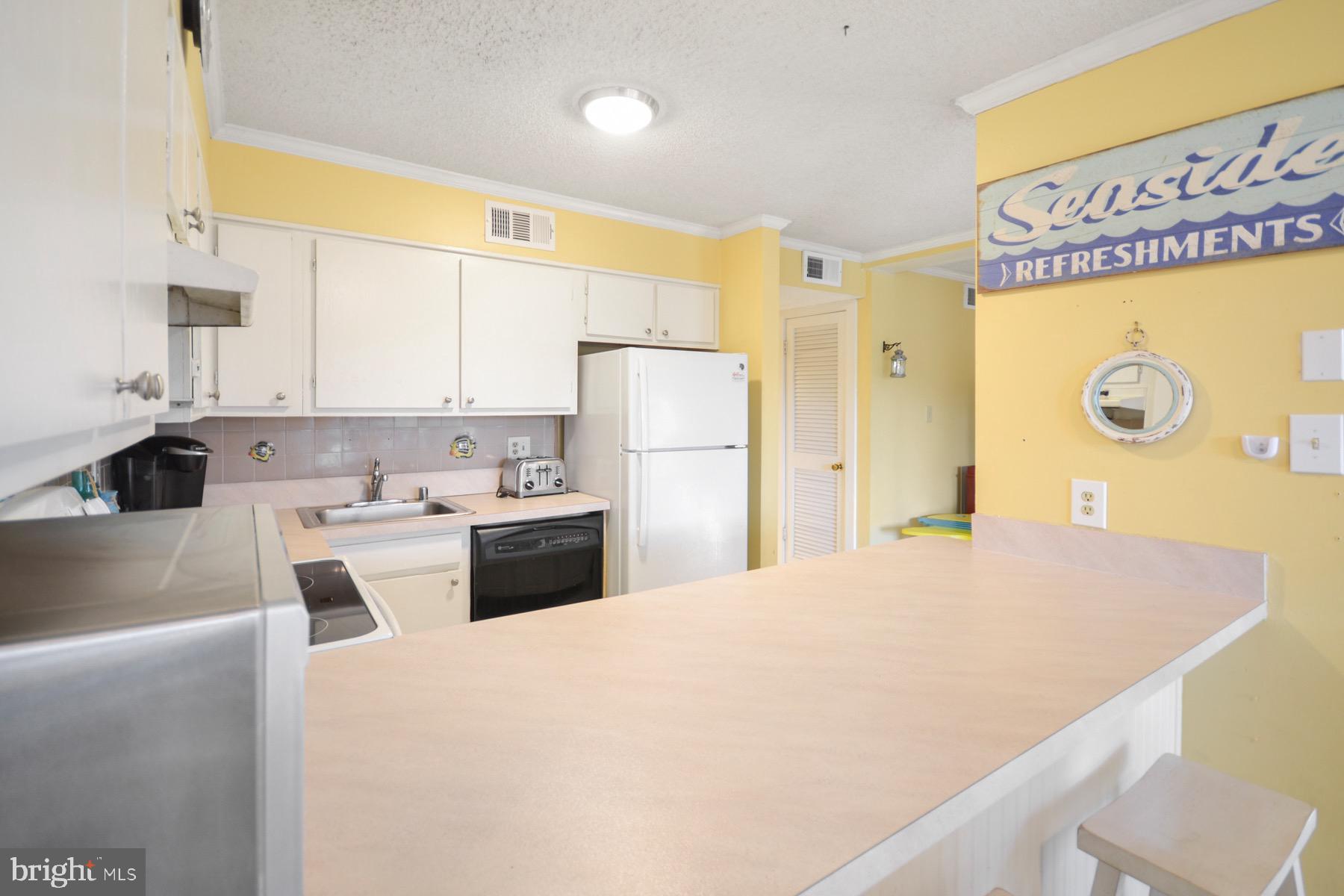 119 Old Landing Road, Unit 204J Ocean City, MD 21842 - Photo 5 of 35 a kitchen with a refrigerator a stove a sink and a cabinets