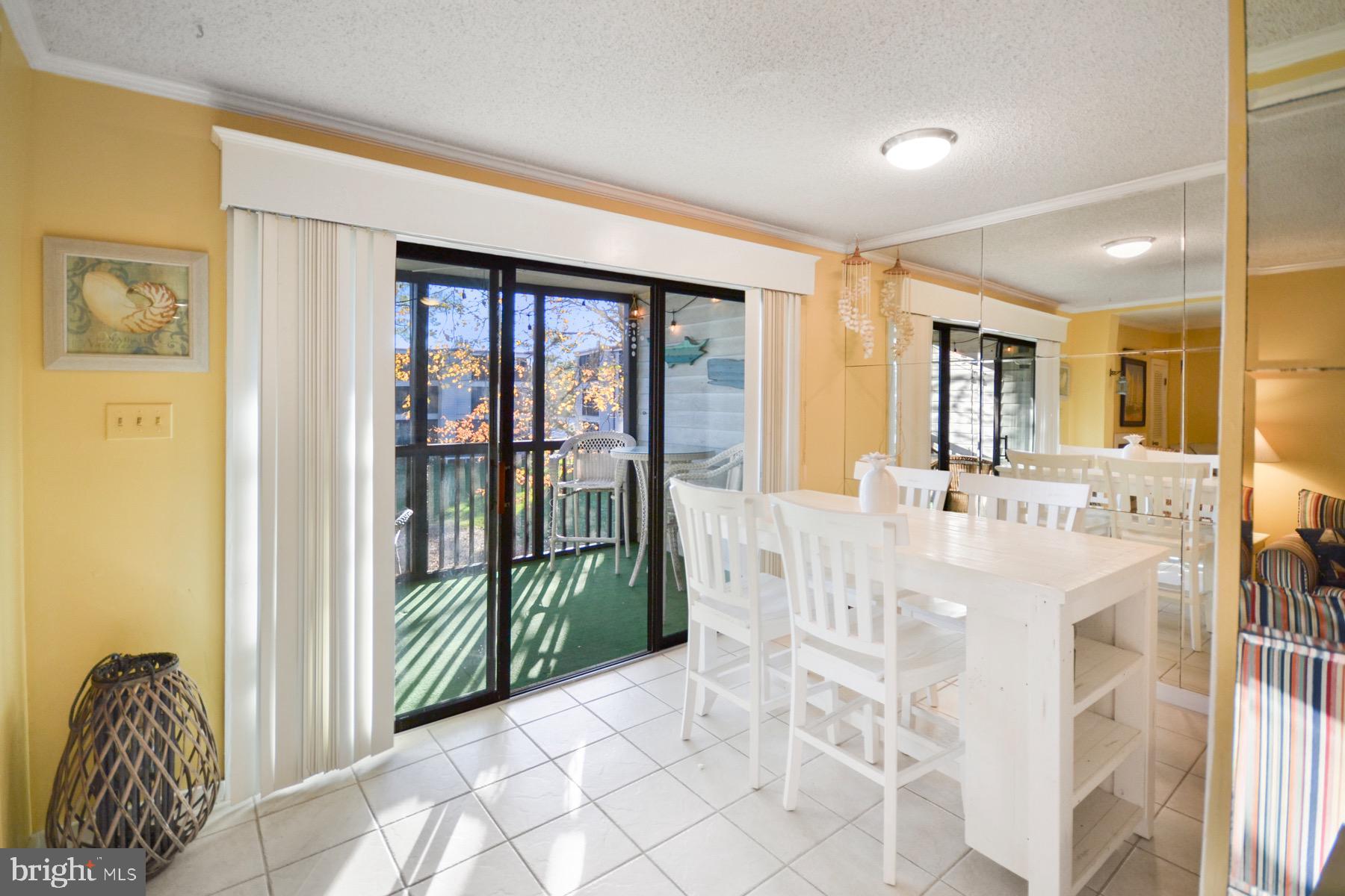 119 Old Landing Road, Unit 204J Ocean City, MD 21842 - Photo 6 of 35 a spacious bedroom with a large bed and a chandelier