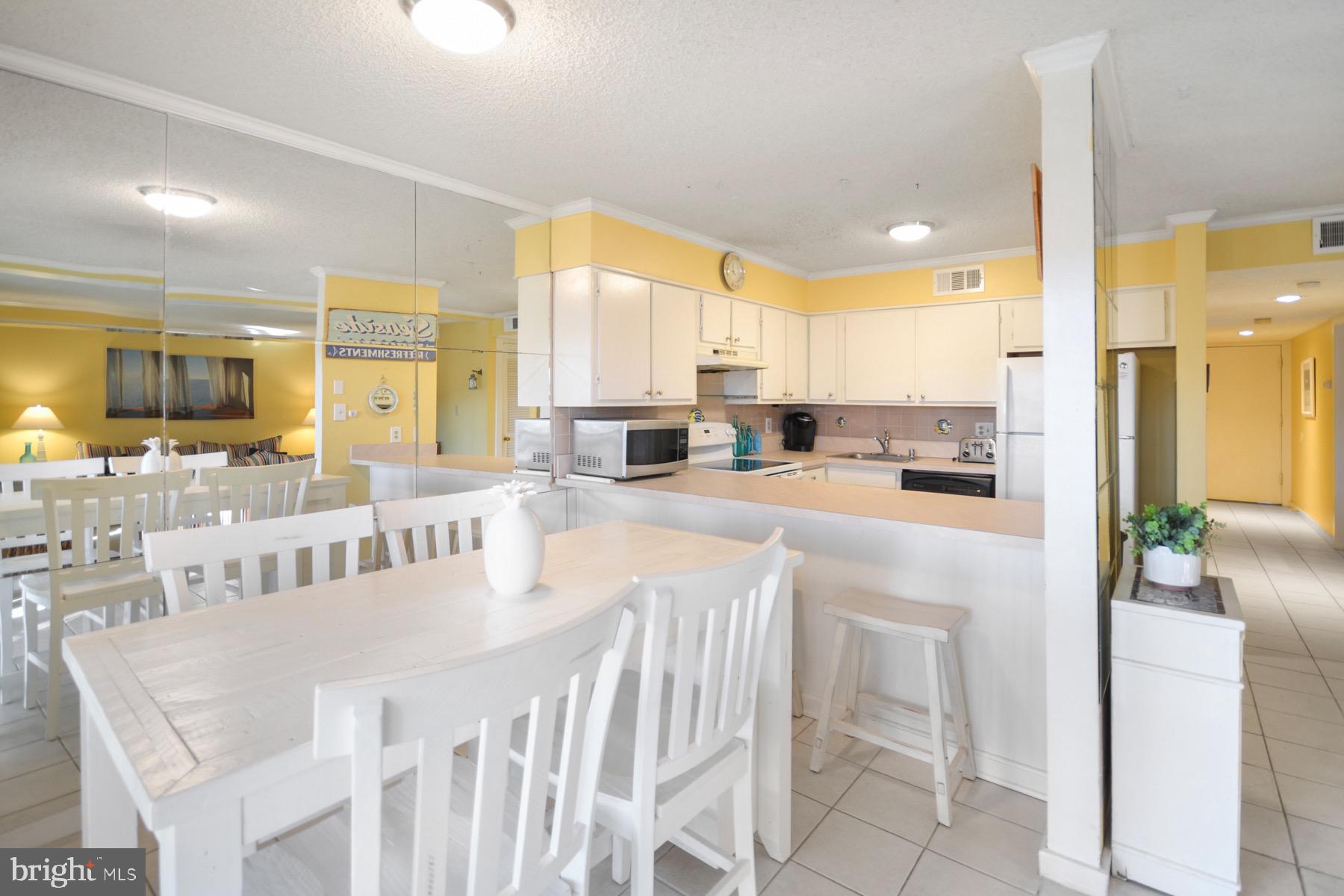 119 Old Landing Road, Unit 204J Ocean City, MD 21842 - Photo 7 of 35 a large white kitchen with a large window and kitchen island