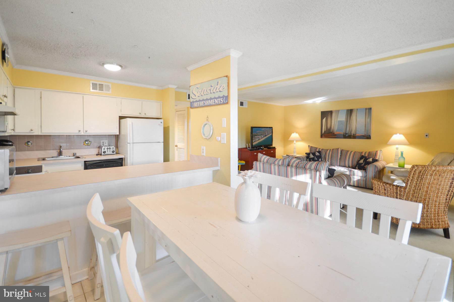 119 Old Landing Road, Unit 204J Ocean City, MD 21842 - Photo 8 of 35 a large white kitchen with a large window and white table