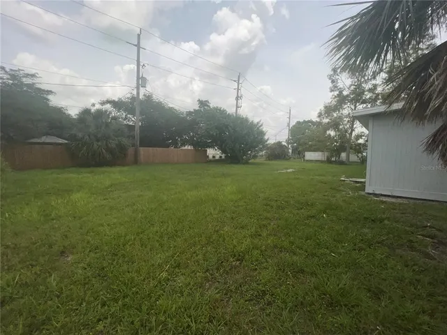 a backyard of a house with potted plants and large trees