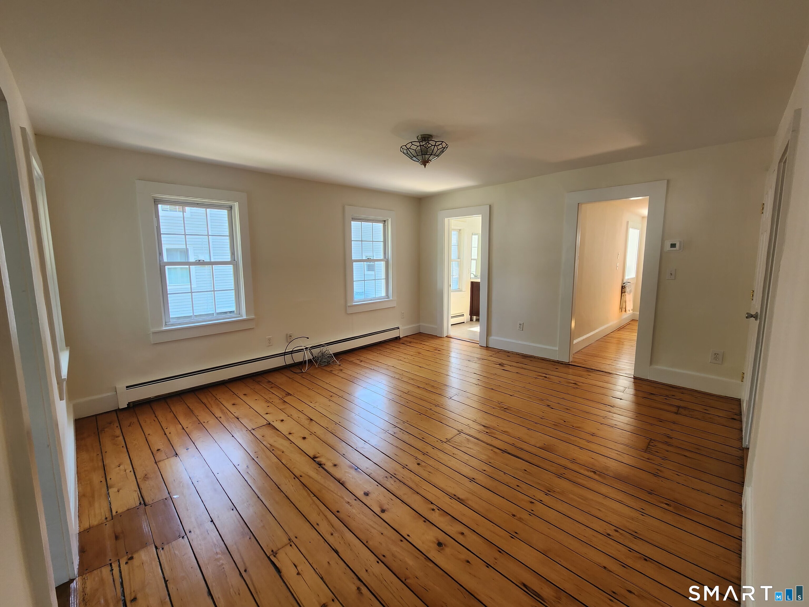 82 State Street, Unit 1 Guilford, CT 06437 - Photo 6 of 9 an empty room with wooden floor and windows