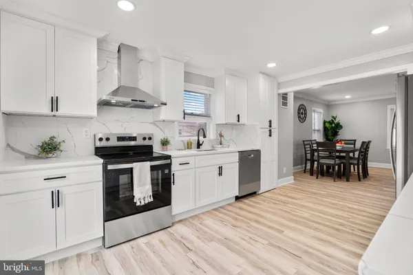 a kitchen with stainless steel appliances a white stove top oven and white cabinets