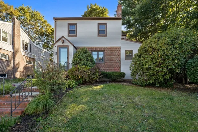 a front view of a house with a yard and trees
