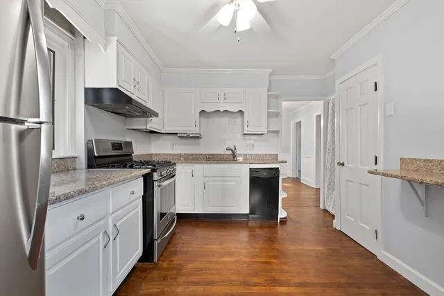 a kitchen with a sink cabinets and wooden floor