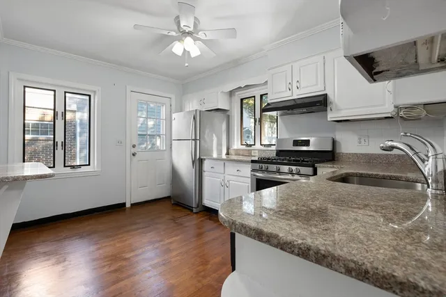 a kitchen with stainless steel appliances granite countertop a sink a stove and cabinets