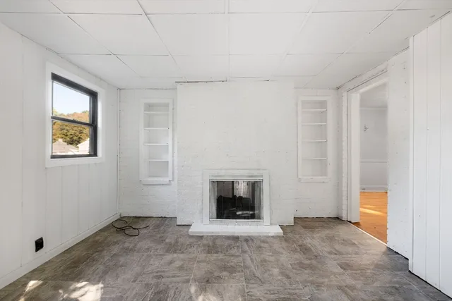 a view of an empty room with a fireplace and a window