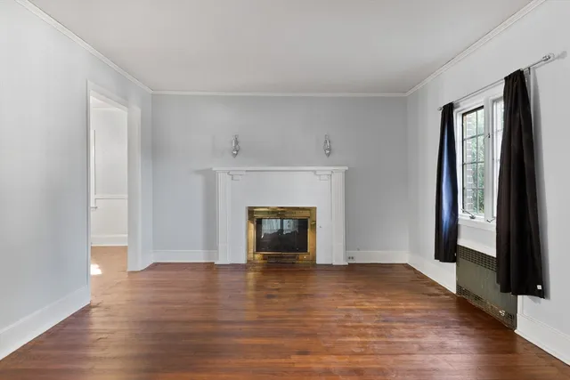 a view of a livingroom with wooden floor and a fireplace