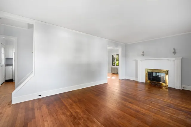 an empty room with wooden floor and fireplace