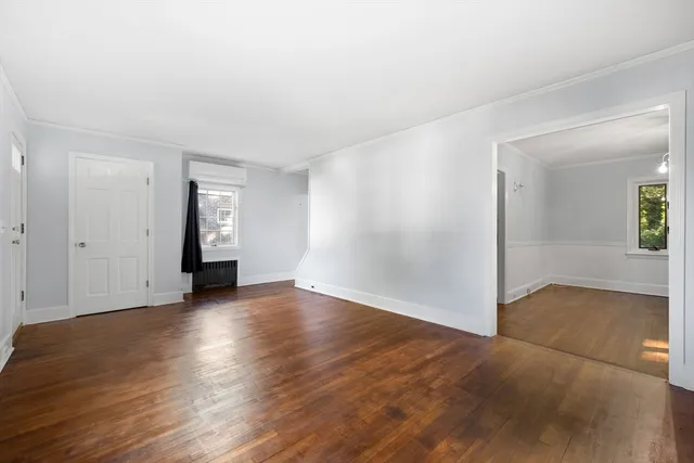 an empty room with wooden floor and mirror
