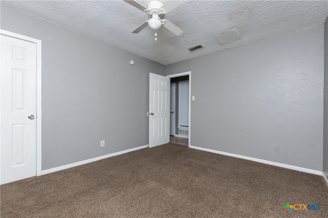 1520 McCarthy Avenue Killeen, TX 76549 - Photo 15 of 23 an empty room with a chandelier fan and windows
